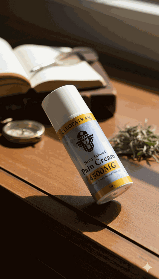 Cleopatra hemp infused pain cream 4500MG bottle on wooden table with books and plant background